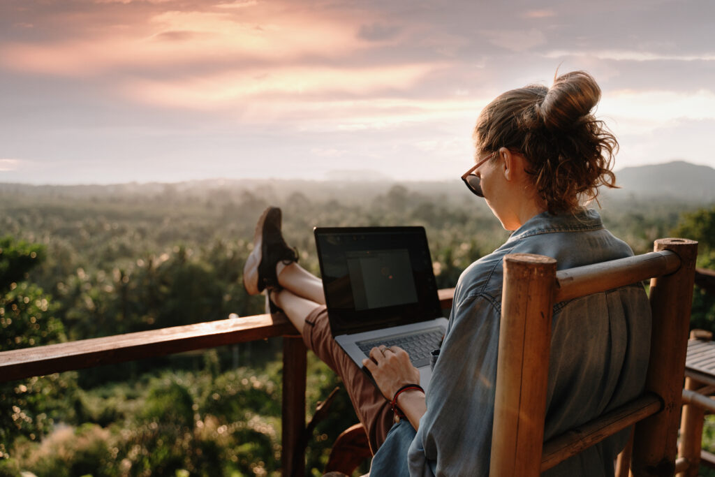 Young business woman working at the computer in cafe on the rock Benefits of moving to the cloud
